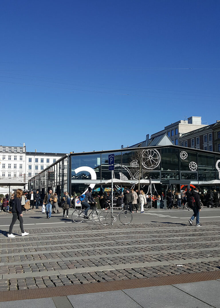 Eine gläserne Markthalle vor blauem Himmel