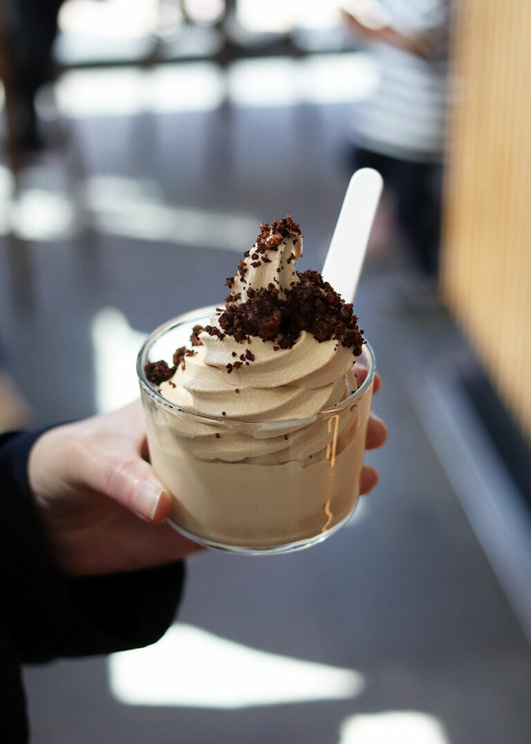 Eine Hand hält ein Glas mit einer Kaffee-Eiscreme