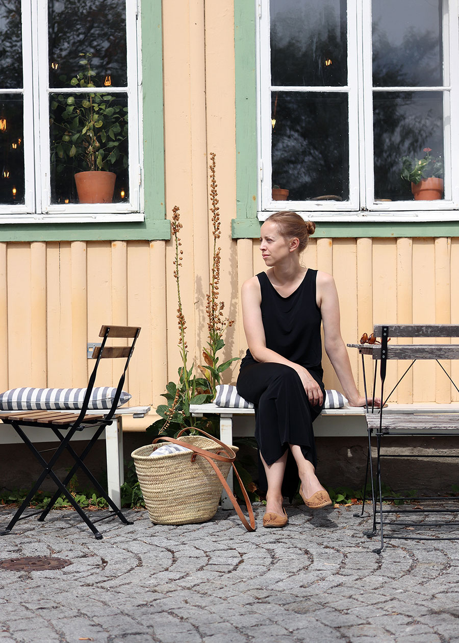 Eine Frau sitzt vor einem Schwedenhaus