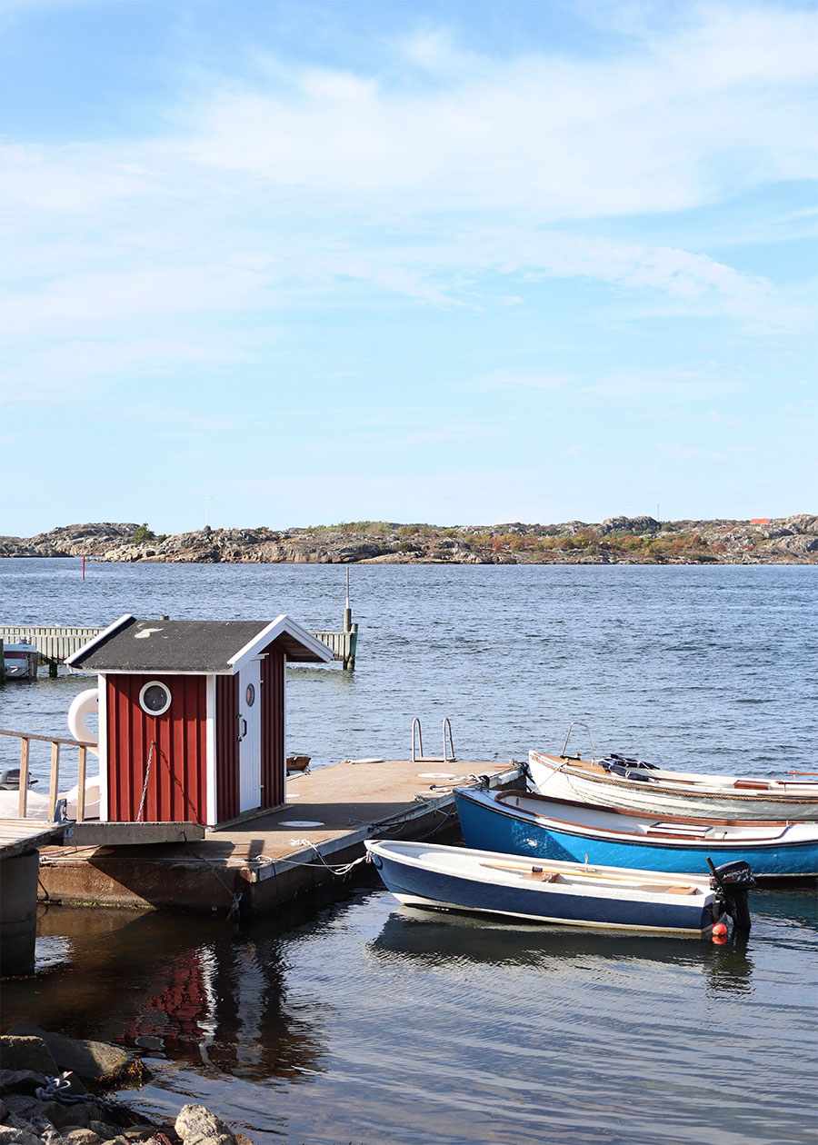 Ein rotes Badehäuschen und Boote am Wasser