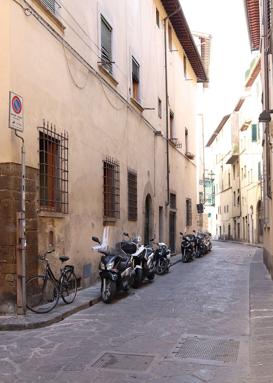 Eine Gasse mit Motorrollern in Florenz