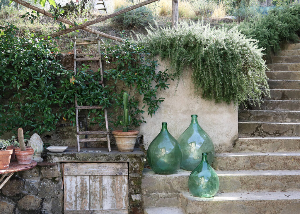 Große, grüne Glasvasen stehen als Dekoration auf einer Steintreppe
